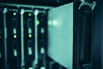 Racks de servidores em um datacenter moderno, com iluminação azulada.