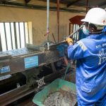 Trabalhador usando equipamento de separação em uma unidade industrial de processamento de minério.