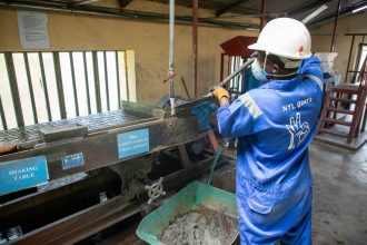 Trabalhador usando equipamento de separação em uma unidade industrial de processamento de minério.