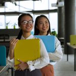 Duas profissionais sorrindo em um escritório moderno.