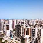 Vista aérea de Fortaleza, com edifícios modernos sob o céu azul.