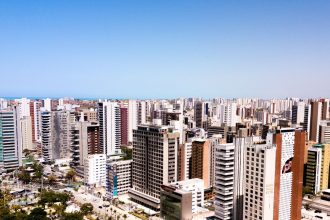 Vista aérea de Fortaleza, com edifícios modernos sob o céu azul.