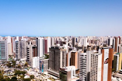 Vista aérea de Fortaleza, com edifícios modernos sob o céu azul.