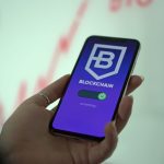 Mão segurando um smartphone que exibe uma carteira digital de criptomoedas e elementos de blockchain